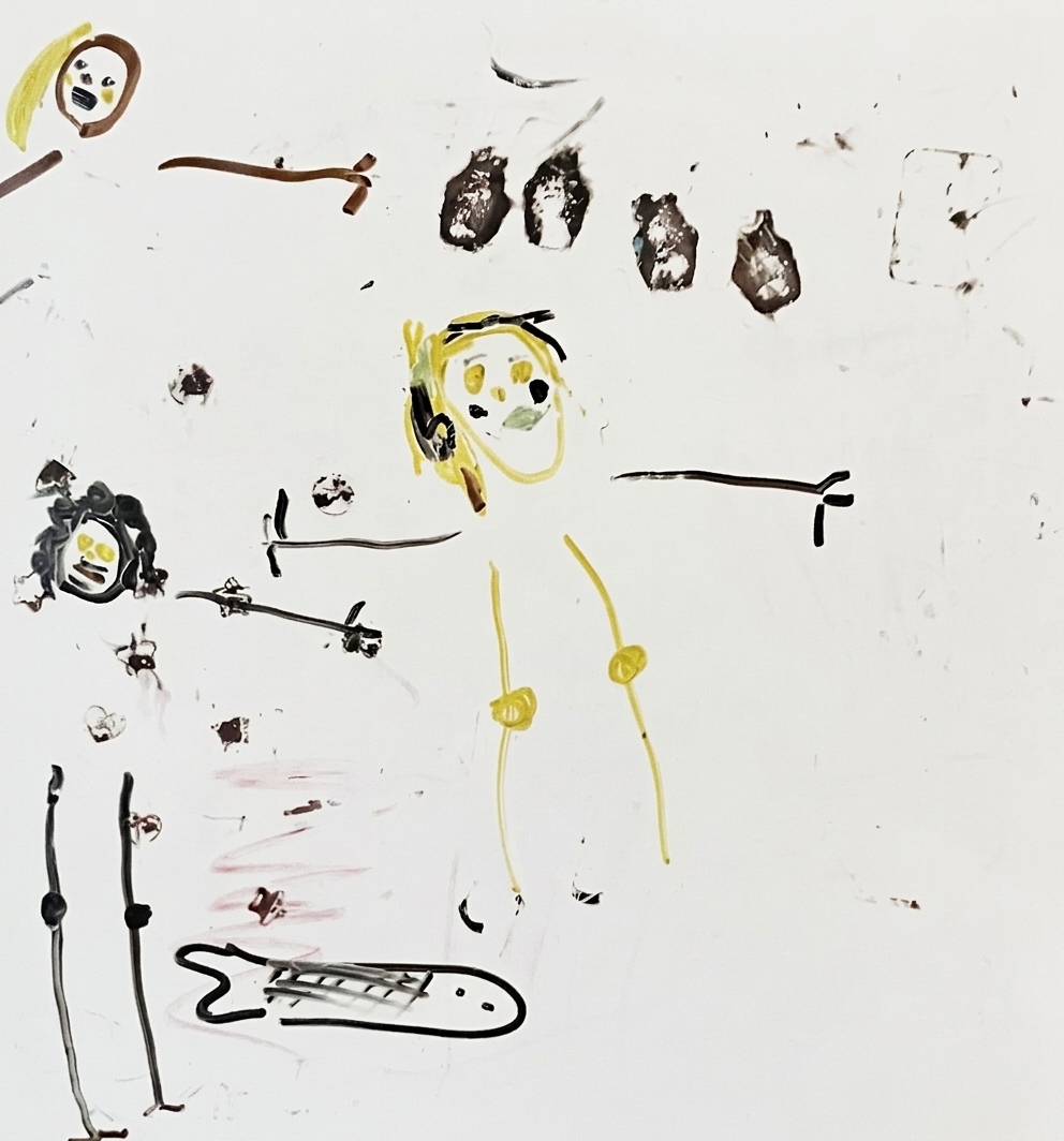 Scribbled figures, a fish, and various abstract shapes fill the surface of a white board.